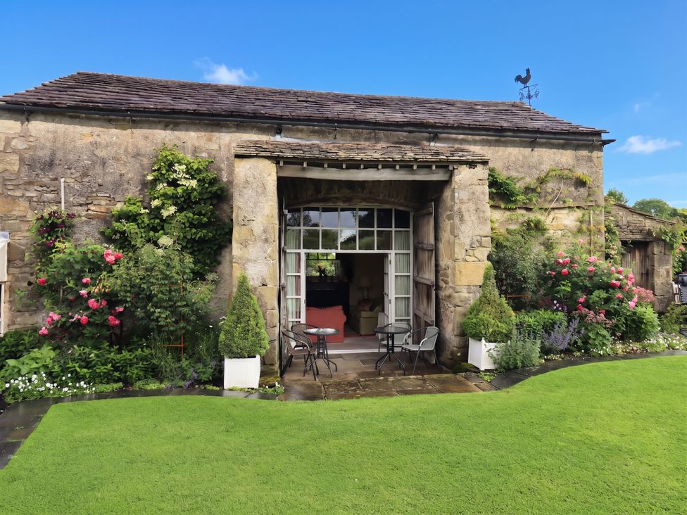 An outdoor area with a building and garden at The Garden Rooms Lawkland Austwick