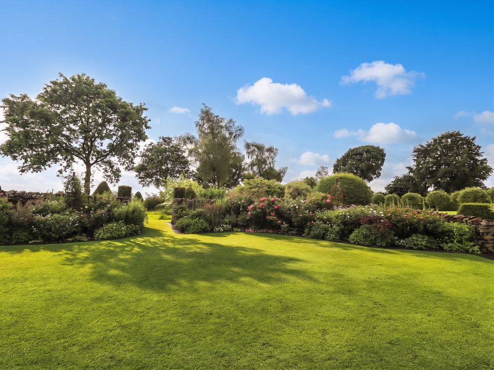 A garden with flowers and trees at The Garden Rooms Lawkland Austwick