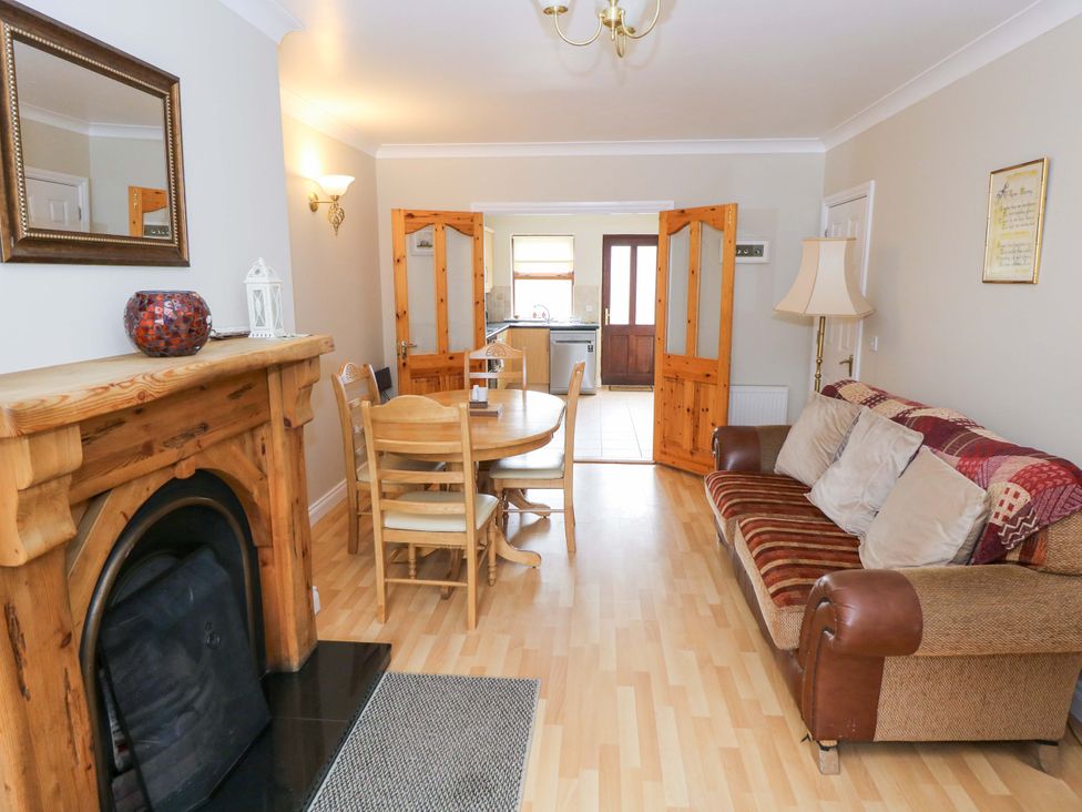 A living room with a fireplace, sofa, dining table and chairs at Aisling in Foxford near Ballina, County Mayo