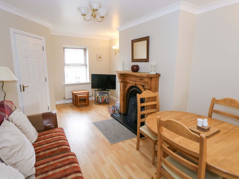 A living room with a sofa, dining table and television at Aisling in Foxford near Ballina, County Mayo