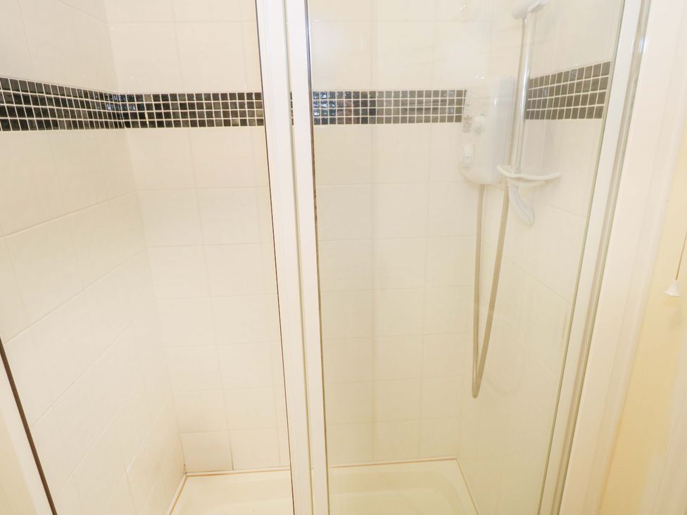 A shower area with tile walls and a showerhead at Aisling in Foxford near Ballina, County Mayo