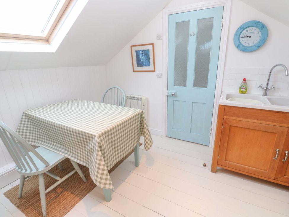 A kitchen with a table and chairs at Badgers Loft in Sennen Cove