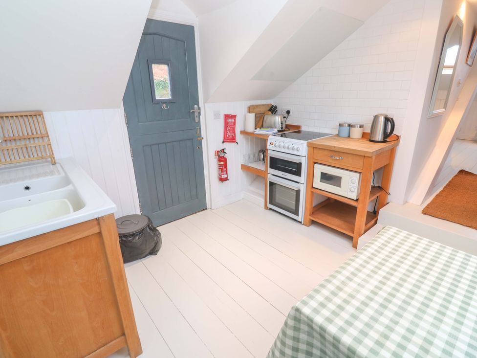 A kitchen with a stove and countertop at Badgers Loft in Sennen Cove