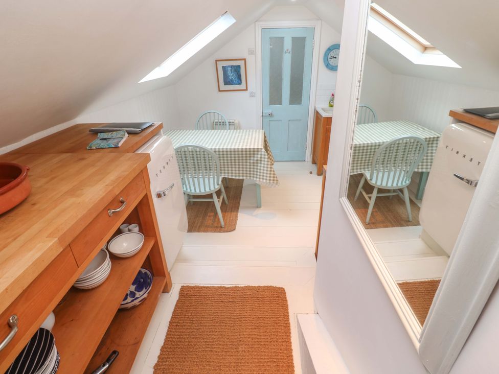 A kitchen with a table and chairs at Badgers Loft in Sennen Cove