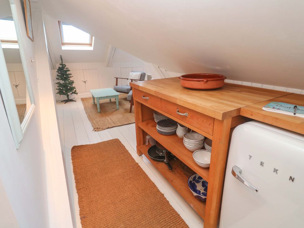 A kitchen with dining table and chairs at Badgers Loft in Sennen Cove