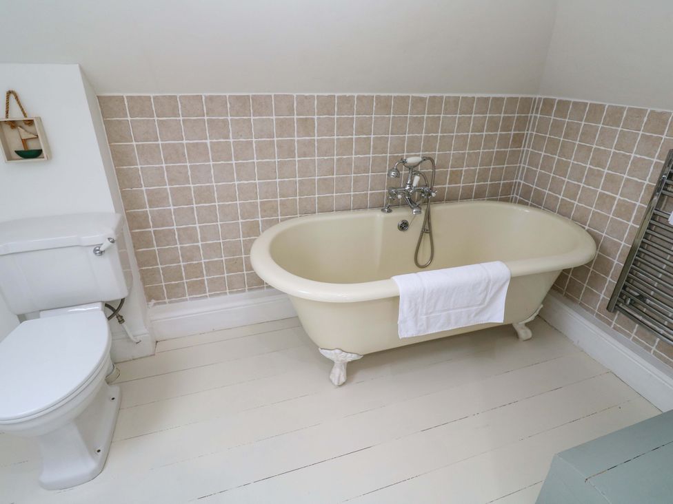 A bathroom featuring a bathtub and a toilet at Badgers Loft in Sennen Cove