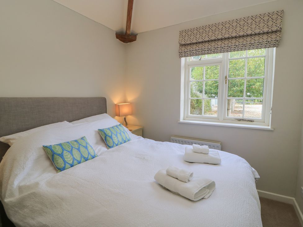 A bedroom with a bed and a lamp at The Cider Press, Motcombe