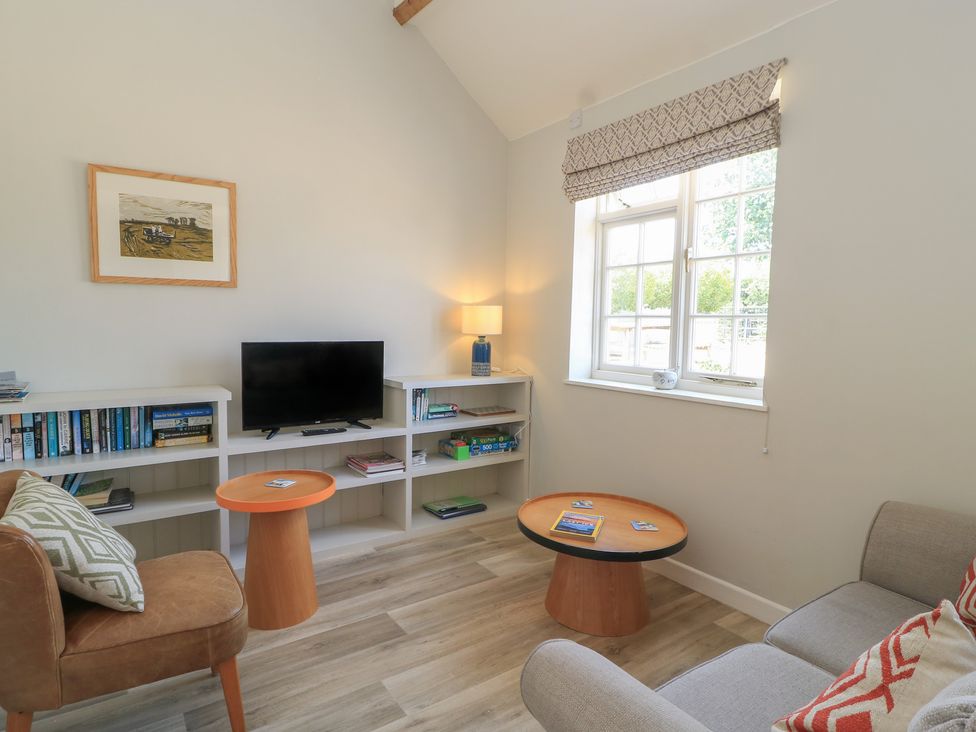 A living room with a sofa and television at The Apple Shed, Motcombe