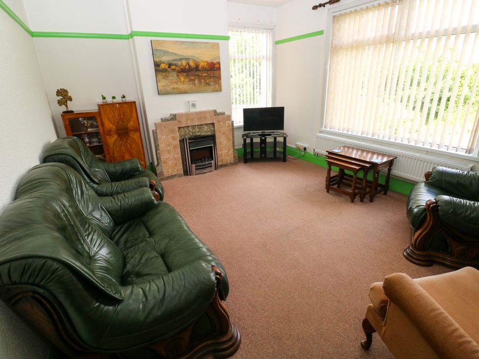 A living room with sofas and a television at White Thorns in Haverfordwest