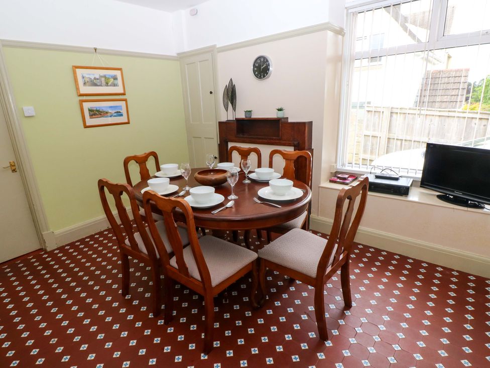 A dining room with a table set for six at White Thorns in Haverfordwest