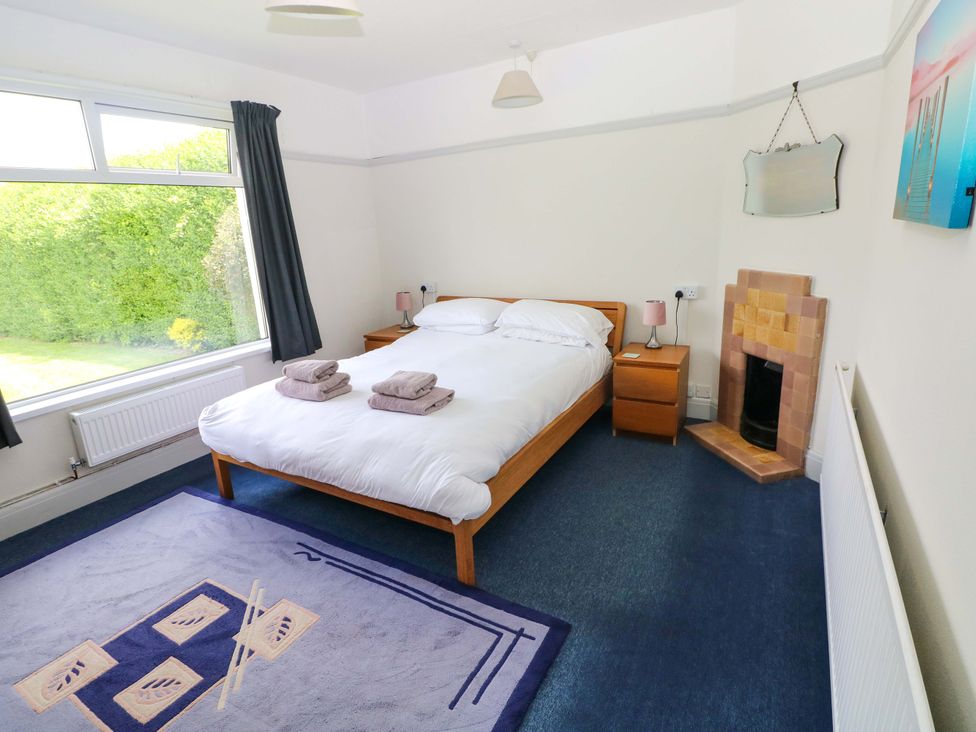 A bedroom with a double bed and window at White Thorns in Haverfordwest