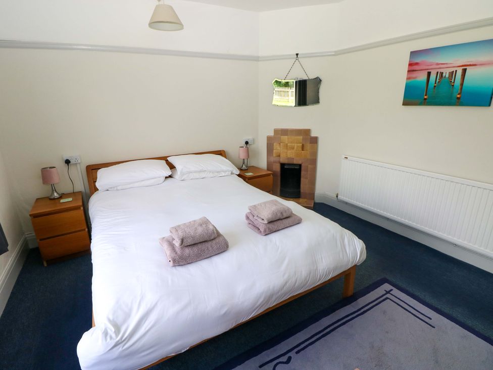 A bedroom with a bed and towels on it at White Thorns in Haverfordwest