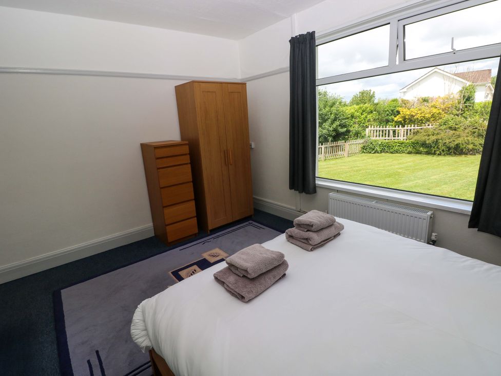 A bedroom with a bed and towels on it at White Thorns in Haverfordwest