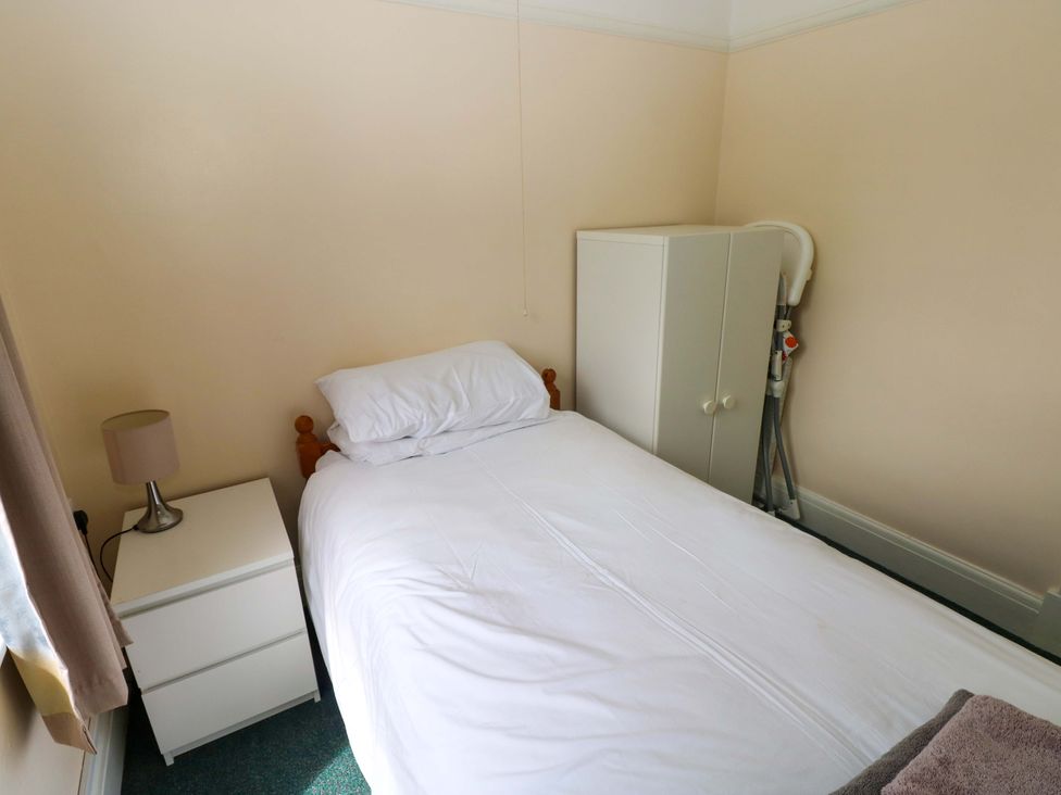 A bedroom with a bed and nightstand at White Thorns in Haverfordwest
