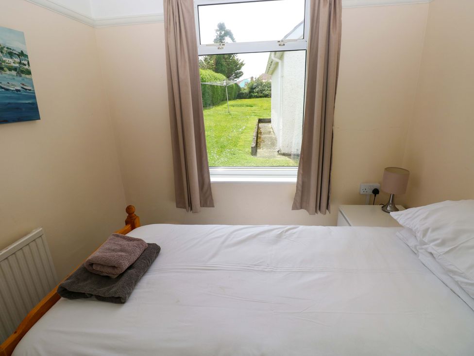 A bedroom with a bed and towels on it at White Thorns in Haverfordwest