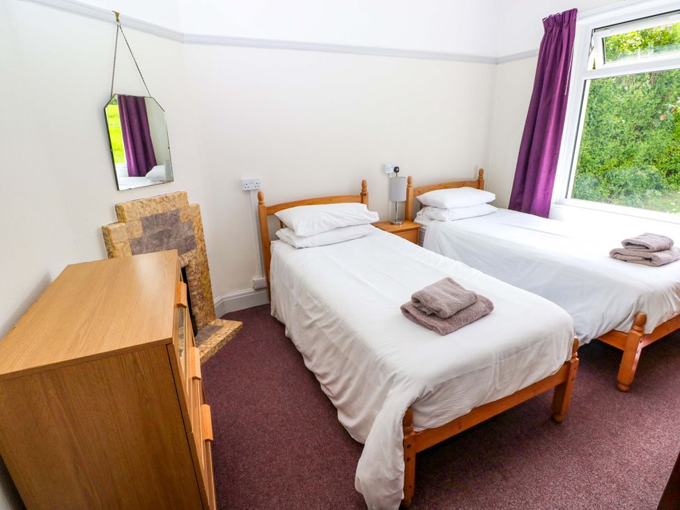 A bedroom with two single beds and a dresser at White Thorns in Haverfordwest
