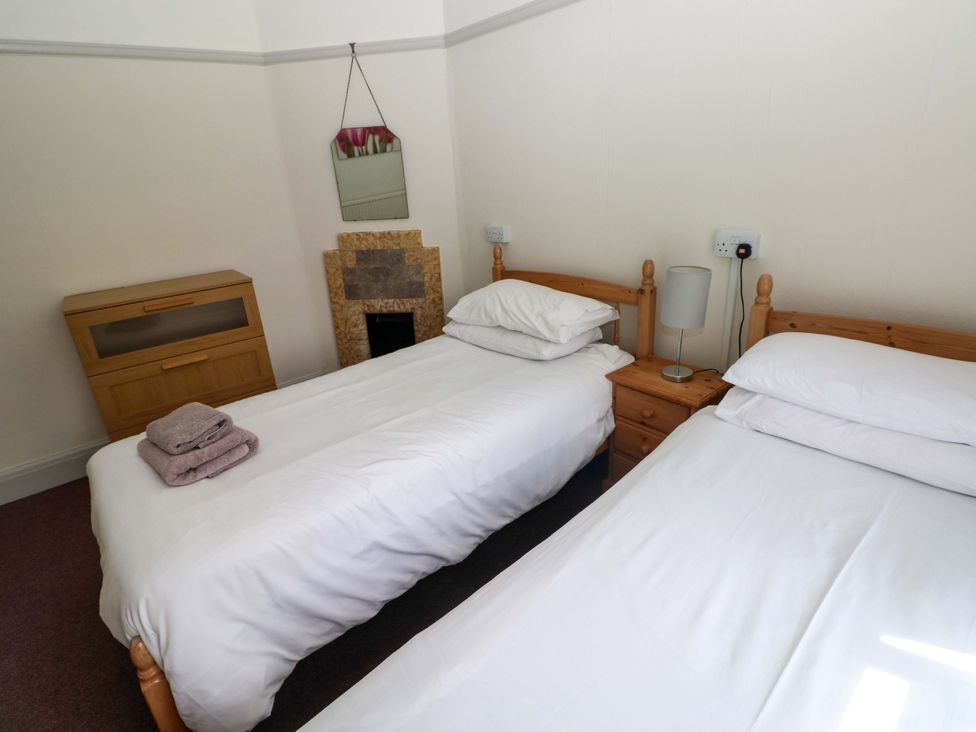 A bedroom with twin beds and a nightstand at White Thorns in Haverfordwest