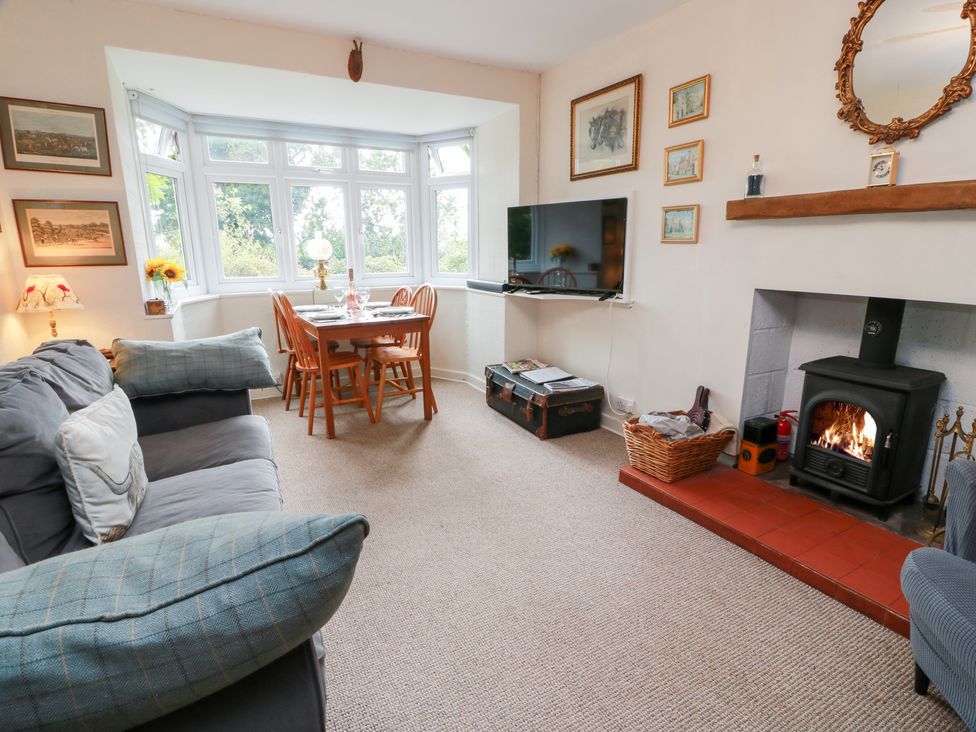 A living room with a sofa and dining table at Charlies Cottage in Swinton