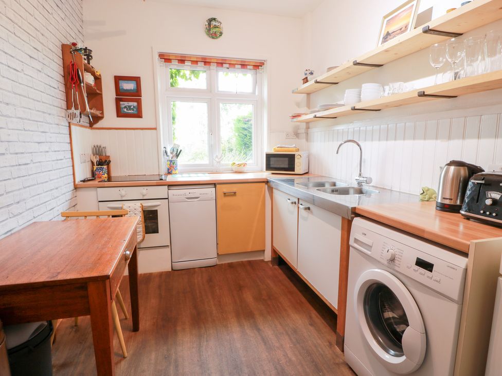 A kitchen with appliances and a window at Charlies Cottage in Swinton