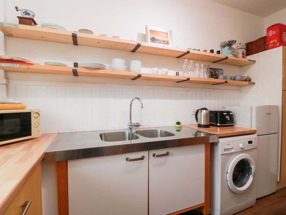 A kitchen with a sink and appliances at Charlies Cottage in Swinton