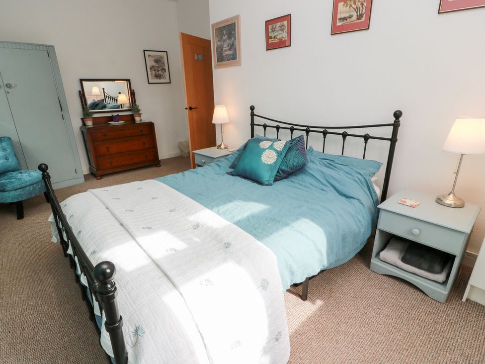 A bedroom with a bed and lamp at Charlies Cottage in Swinton