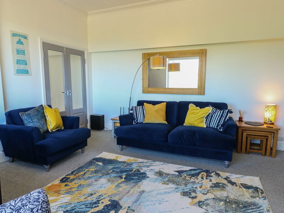 A living room with a sofa and armchair at Little Orme View in Llandudno