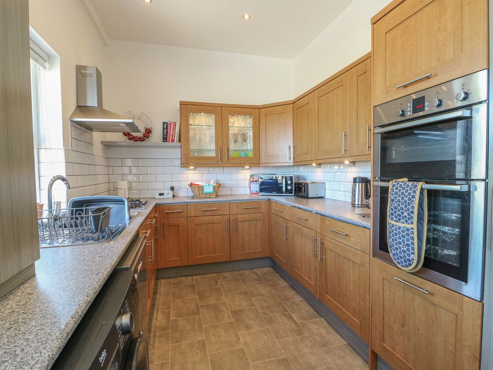 A kitchen with cabinets and appliances at Little Orme View in Llandudno