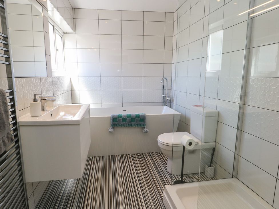 A bathroom with a tub and shower at Little Orme View in Llandudno