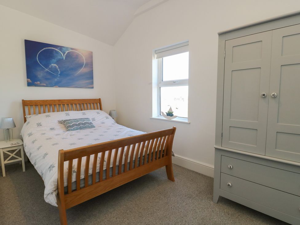 A bedroom with a bed and wardrobe at Little Orme View in Llandudno
