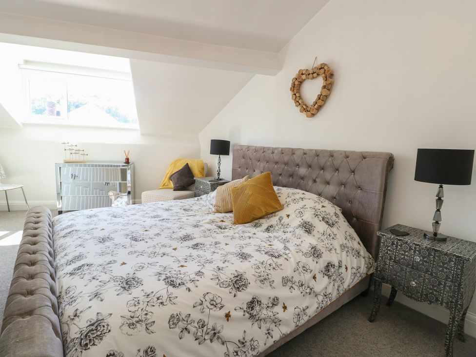 A bedroom with a bed and a side table at Little Orme View in Llandudno