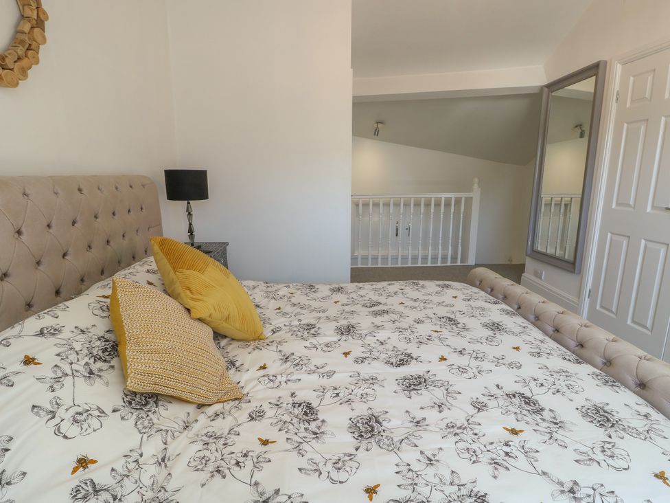 A bedroom with a bed and bedside lamp at Little Orme View in Llandudno