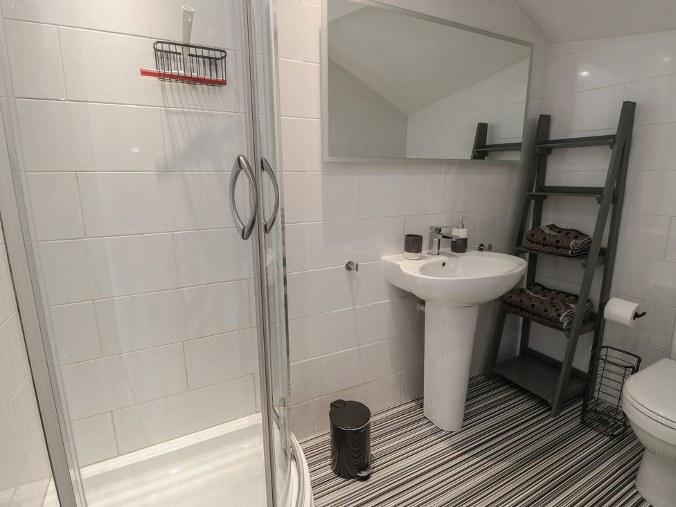 A bathroom with a shower, sink and toilet at Little Orme View in Llandudno