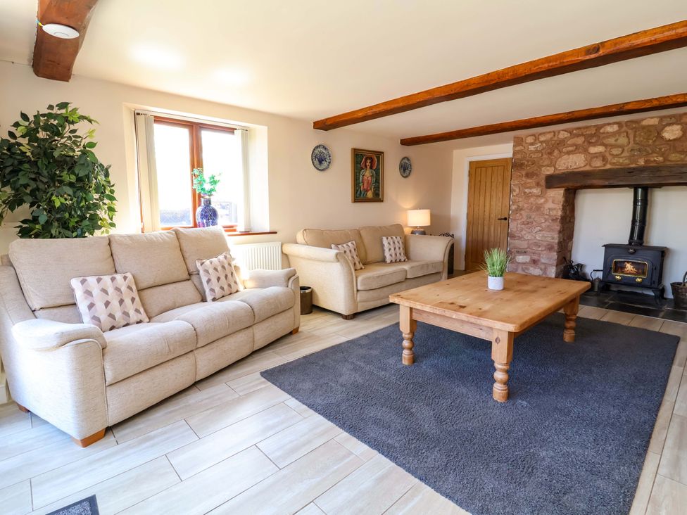 A living room with sofas and a wooden table at The Linhay Washford near Watchet