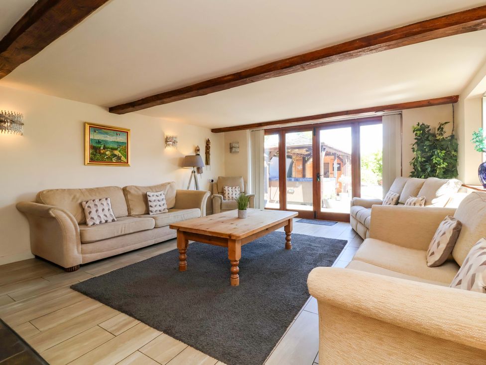 A living room with sofas and a wooden table at The Linhay Washford near Watchet