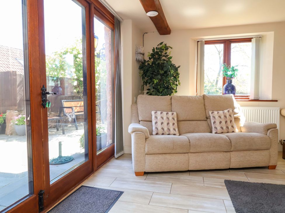 A living room with a sofa and windows at The Linhay in Washford near Watchet