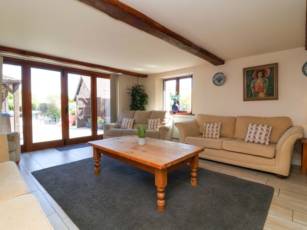 A living room with sofas and a wooden table at The Linhay in Washford near Watchet