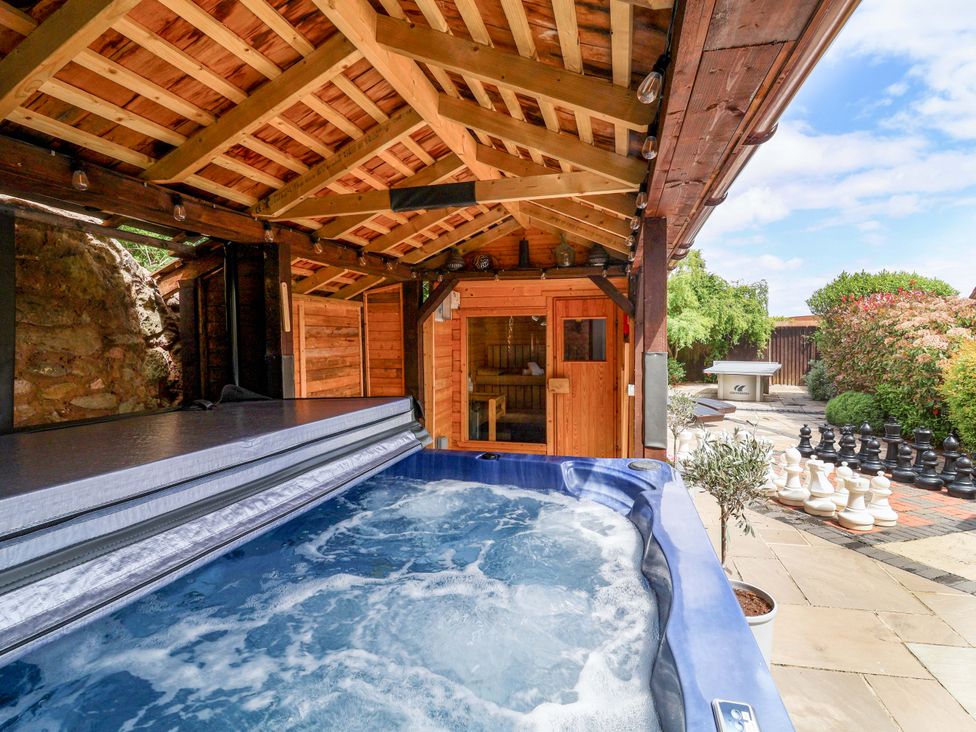 An outdoor area with a hot tub and sauna at The Linhay in Washford near Watchet