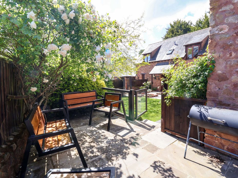 A garden area with chairs and a grill at The Linhay in Washford near Watchet