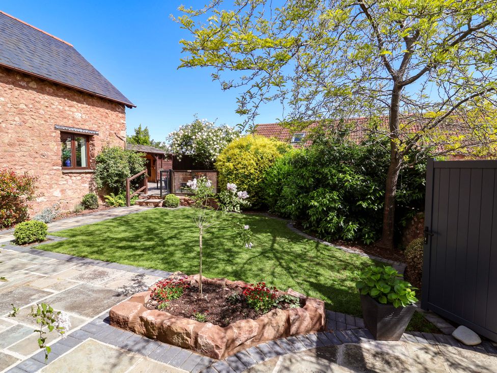 A garden with a stone path and plants at The Linhay Washford near Watchet