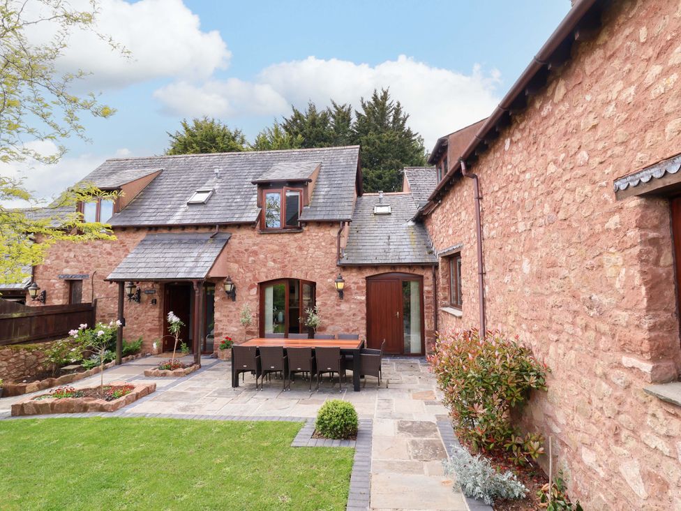 A patio with dining table and chairs at The Linhay Washford near Watchet