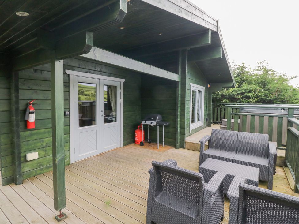 An outdoor seating area with a barbecue grill at Elm Lodge in Ulverston
