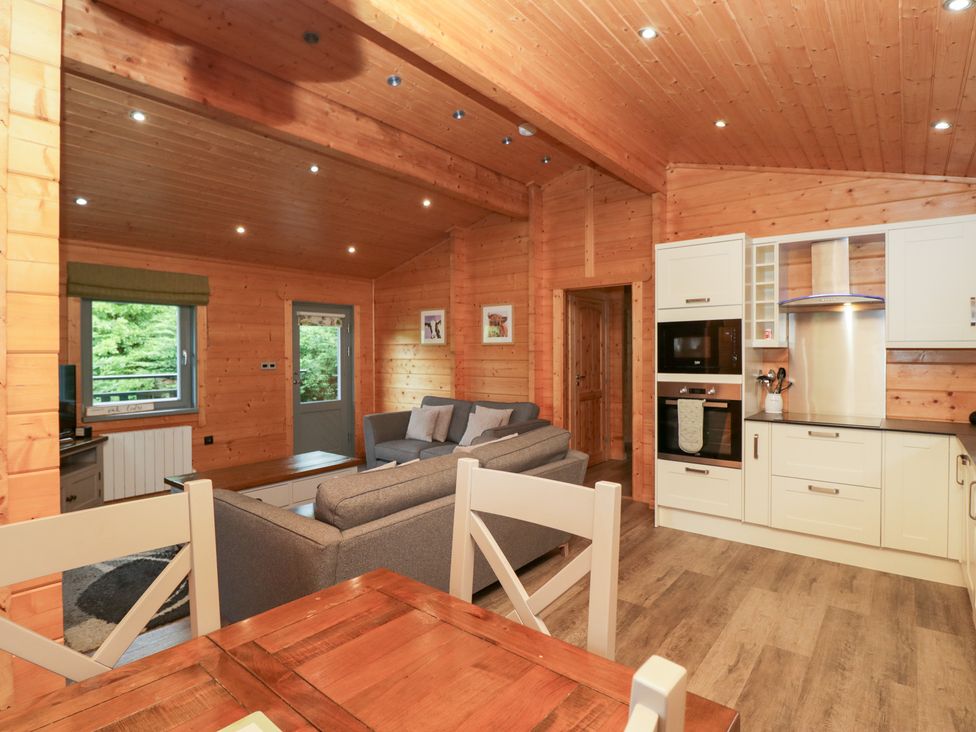 A living room with a sofa and dining table at Elm Lodge in Ulverston