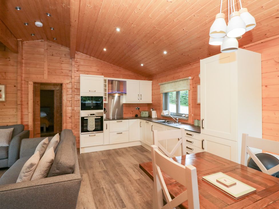 A kitchen with dining area and sofa at Elm Lodge in Ulverston