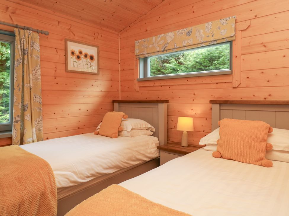 A bedroom with two beds and a window at Elm Lodge in Ulverston