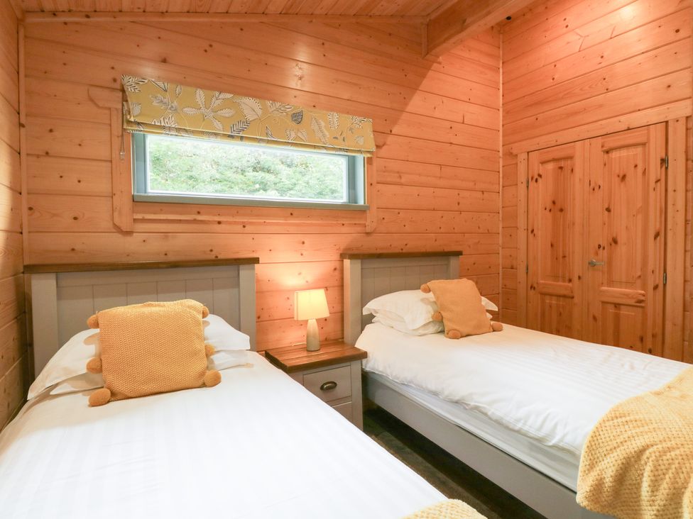 A bedroom with two single beds and a window at Elm Lodge in Ulverston
