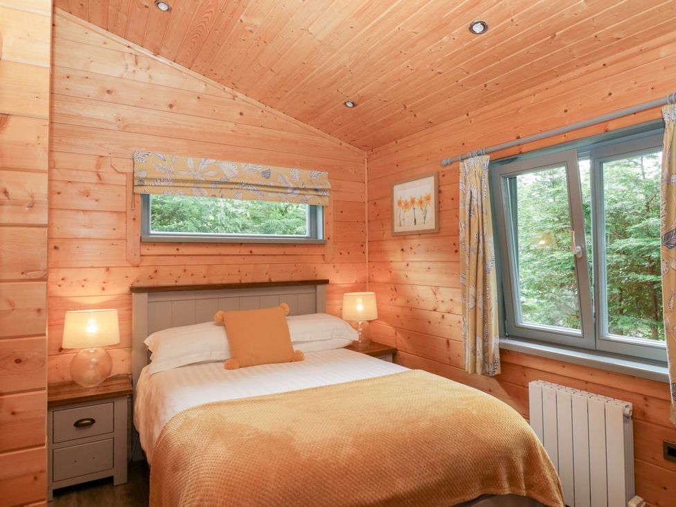 A bedroom with a bed and window at Elm Lodge in Ulverston