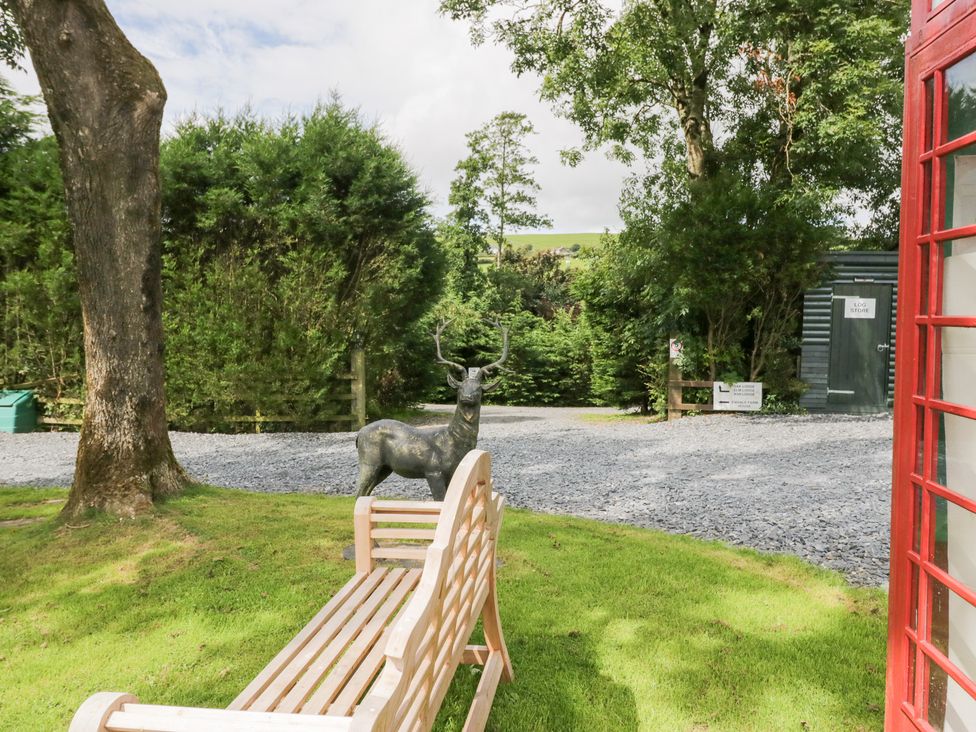 A garden area with a bench and deer statue at Elm Lodge in Ulverston