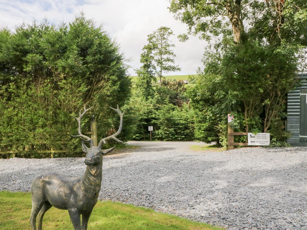 An outdoor area with a deer statue and gravel path at Elm Lodge in Ulverston