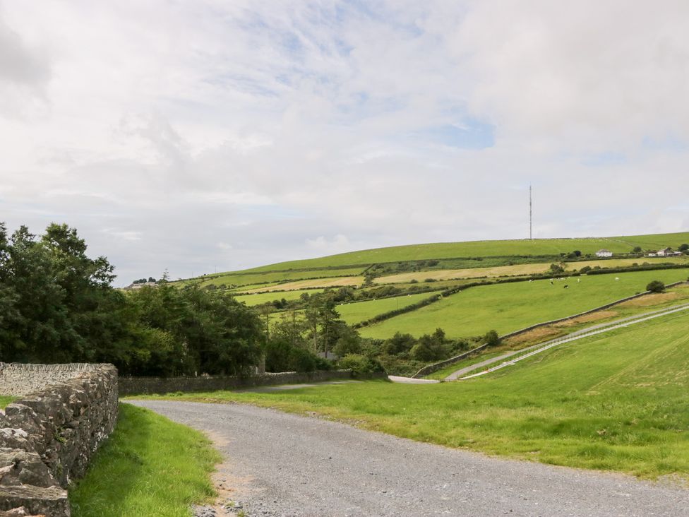 A landscape with a winding road, hills, and a telecommunications tower at Elm Lodge in Ulverston