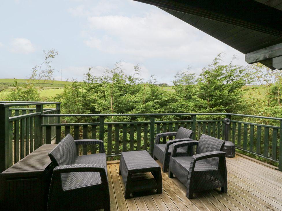 An outdoor seating area with chairs and a table at Elm Lodge in Ulverston